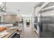 Open-concept kitchen and dining area with stainless appliances, white cabinets, and wood-look tile flooring at 2236 Oconnel Dr, Ormond Beach, FL 32174