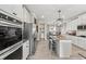 Open-concept kitchen with stainless appliances, island seating, and a view to the dining area and laundry room at 2236 Oconnel Dr, Ormond Beach, FL 32174