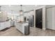 Spacious kitchen boasts stainless steel appliances, white cabinetry, a central island, and modern lighting at 2236 Oconnel Dr, Ormond Beach, FL 32174