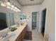 Bathroom with double sinks, vanity with drawers, large mirror, and access to a separate shower area at 2327 Addison Ave, Clermont, FL 34711