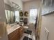 Well-lit bathroom with a modern vanity, decorative wreaths, and a shower with a stylish patterned curtain at 2327 Addison Ave, Clermont, FL 34711