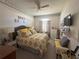 Comfortable bedroom featuring neutral walls with decorative accents and a queen bed with patterned yellow and gray bedding at 2327 Addison Ave, Clermont, FL 34711