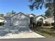Charming single-story home with a well-manicured lawn, two-car garage, and lovely landscaping under a clear blue sky at 2327 Addison Ave, Clermont, FL 34711