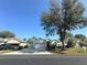 Traditional home with three car garage, mature shade trees, and a tidy front lawn at 2327 Addison Ave, Clermont, FL 34711