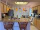 Well-lit kitchen features granite countertops, wooden cabinetry, stainless steel appliances, and stylish pendant lighting at 2327 Addison Ave, Clermont, FL 34711