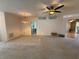 Expansive living room featuring neutral carpet, a ceiling fan, and doorway leading to front entrance at 2327 Addison Ave, Clermont, FL 34711