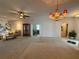 Spacious living room with carpet floors, neutral walls, a ceiling fan, and an ornate chandelier at 2327 Addison Ave, Clermont, FL 34711