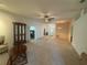 Expansive living room featuring plush carpeting, a decorative ceiling fan, and a charming entryway with a glass-paneled front door at 2327 Addison Ave, Clermont, FL 34711