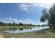 Scenic view of a tranquil pond reflecting the sky, surrounded by a lush landscape and golf course at 2327 Addison Ave, Clermont, FL 34711