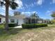 The home features a screened lanai, stucco siding, and manicured landscaping at 2327 Addison Ave, Clermont, FL 34711