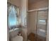 Bathroom shower featuring clear glass doors, tiled walls, a built-in bench, and a grab bar for convenience at 2327 Addison Ave, Clermont, FL 34711