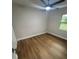 Bright bedroom with wood flooring, a ceiling fan, and a window overlooking the exterior at 266 N High St, Lake Helen, FL 32744