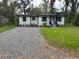 Charming single-story home with gravel driveway and well-maintained landscaping at 266 N High St, Lake Helen, FL 32744
