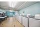 Bright laundry room with multiple white washing machines and folding tables at 2711 N Halifax Ave # 890, Daytona Beach, FL 32118