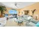 Bright living room featuring comfortable seating, a ceiling fan, and sliding glass doors to the outside balcony at 2711 N Halifax Ave # 890, Daytona Beach, FL 32118