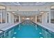 Bright indoor pool area with blue tiled pool, overhead lighting, and large windows at 2967 S Atlantic Ave # 1203, Daytona Beach Shores, FL 32118