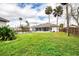 View of the large backyard with mature trees and a covered lanai at 30 Division Ave, Ormond Beach, FL 32174