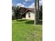 Spacious backyard features lush green lawn, mature trees, and screened in porch at 301 Paradise Ln, Edgewater, FL 32132