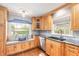 Kitchen details: Window seat, stainless dishwasher, granite counters, and natural wood cabinetry at 317 Oak Hill Dr, Altamonte Springs, FL 32701