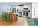 Bright and airy kitchen blends with living area with stainless steel appliances and stylish colorful bar stools at 3700 S Atlantic Ave # 111, New Smyrna Beach, FL 32169