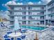 Bright condo building offers a luxurious pool with plenty of seating for residents to relax and enjoy the sun at 3700 S Atlantic Ave # 111, New Smyrna Beach, FL 32169