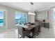 Elegant dining room with modern chandelier and sliding door to private balcony at 3703 S Atlantic Ave # 507, Daytona Beach Shores, FL 32118