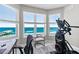Bright exercise room with modern equipment and a stunning ocean view from the large windows on a sunny day at 3703 S Atlantic Ave # 507, Daytona Beach Shores, FL 32118