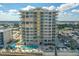 Exterior shot of a condo building with a pool, palm trees, and a glimpse of the river at 3703 S Atlantic Ave # 507, Daytona Beach Shores, FL 32118
