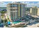 Exterior shot of a condo building with a pool, palm trees, and nearby river at 3703 S Atlantic Ave # 507, Daytona Beach Shores, FL 32118