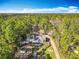 Expansive aerial view of the home and acreage surrounded by lush trees against a clear blue sky at 4252 Quail Ranch Rd, New Smyrna Beach, FL 32168