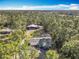 Expansive aerial view of the home and acreage surrounded by lush trees against a blue sky at 4252 Quail Ranch Rd, New Smyrna Beach, FL 32168
