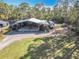 Aerial view of the workshop, with an outdoor table, cars, and tools, with a grassy area nearby at 4252 Quail Ranch Rd, New Smyrna Beach, FL 32168