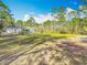 Wide shot of the backyard with a well, patio, firepit, and wooden fence surrounding the property at 4252 Quail Ranch Rd, New Smyrna Beach, FL 32168