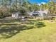 Aerial view of the backyard with the house, patio, firepit, a chicken coop, and a well at 4252 Quail Ranch Rd, New Smyrna Beach, FL 32168