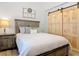 Bedroom with a large wooden bed frame, sliding barn door and earth-tone accents at 4252 Quail Ranch Rd, New Smyrna Beach, FL 32168