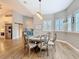 Elegant dining room with wood floors, modern lighting, and adjacent kitchen area at 4252 Quail Ranch Rd, New Smyrna Beach, FL 32168