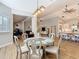 Open-concept dining room with a round table, wood floors, neutral decor, and views into the kitchen and living areas at 4252 Quail Ranch Rd, New Smyrna Beach, FL 32168