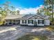 Beautiful exterior of home featuring a covered porch, neutral paint, black shutters, and well-kept grounds at 4252 Quail Ranch Rd, New Smyrna Beach, FL 32168
