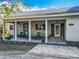Inviting covered front porch with swing and rocking chairs, offering a relaxing outdoor space at 4252 Quail Ranch Rd, New Smyrna Beach, FL 32168