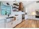 Bright kitchen with stainless steel appliances, stainless steel sink, white cabinets, and open shelving at 4252 Quail Ranch Rd, New Smyrna Beach, FL 32168