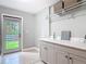 Functional laundry room featuring light grey cabinets, a countertop, and a view of the outdoors at 4252 Quail Ranch Rd, New Smyrna Beach, FL 32168