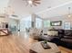 Open concept living room featuring wood floors, a large leather sofa, and access to the kitchen and dining areas at 4252 Quail Ranch Rd, New Smyrna Beach, FL 32168