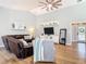 Well-lit living room with wood floors, a sectional sofa, contemporary decor, and plenty of natural light at 4252 Quail Ranch Rd, New Smyrna Beach, FL 32168