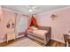 This pink bedroom features a -size bed, wood-look floors, and a window at 509 Kettering Rd, Deltona, FL 32725
