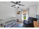 Cozy bedroom with a white crib, comfortable armchair, and a baseball themed decor at 509 Kettering Rd, Deltona, FL 32725