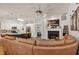 Spacious open-concept living room with fireplace, modern ceiling fan and view into the kitchen at 509 Kettering Rd, Deltona, FL 32725