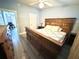 Cozy bedroom with rustic wooden bed, hardwood floors, and ample natural light at 5306 Empire Church Rd, Groveland, FL 34736