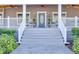 Inviting front porch with rocking chairs and a charming blue door at 5306 Empire Church Rd, Groveland, FL 34736