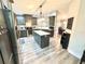 The kitchen features dark gray cabinets, stainless steel appliances, and an island with a sink at 5306 Empire Church Rd, Groveland, FL 34736
