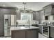 The kitchen features dark gray cabinets, stainless steel appliances, and a center island with a sink at 5306 Empire Church Rd, Groveland, FL 34736